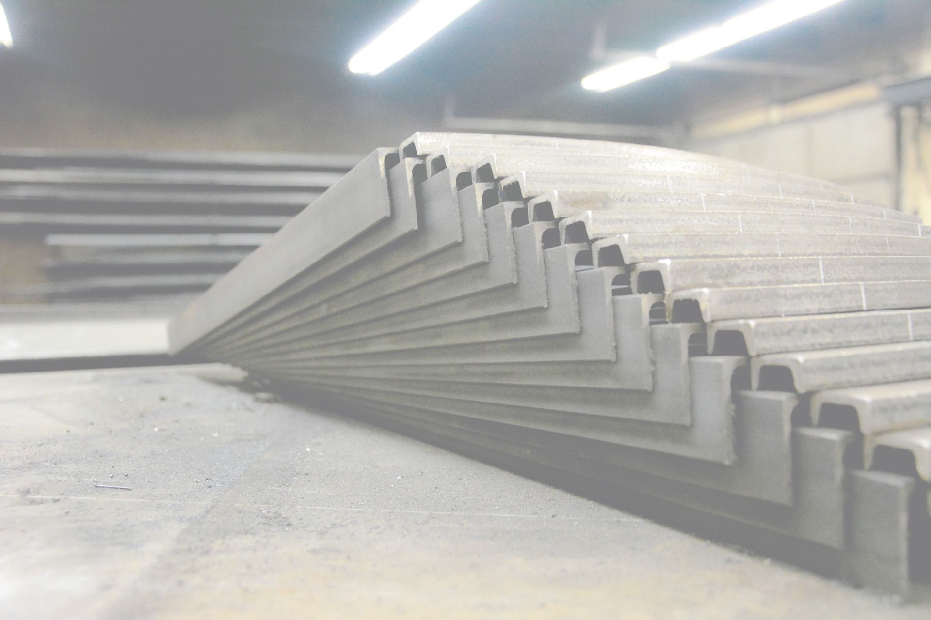 A bunch of metal pieces are stacked on top of each other in a warehouse.