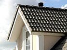 a white house with a black tiled roof and a window .