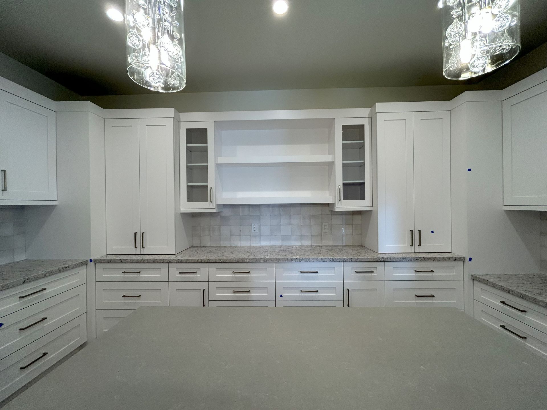 A kitchen with white cabinets and granite counter tops