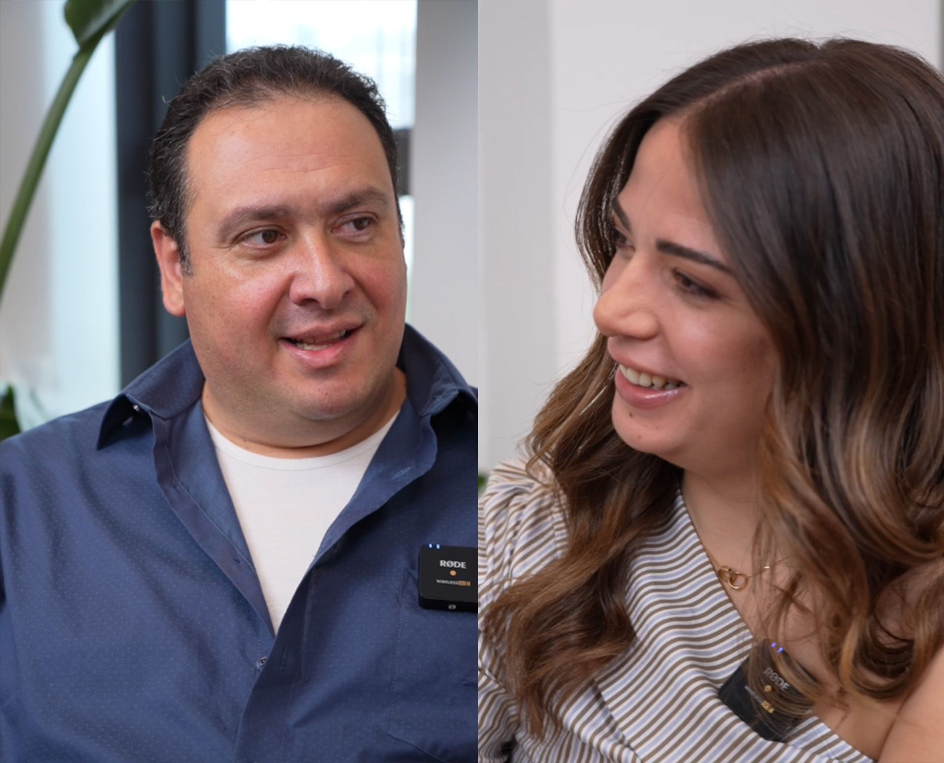 Man in blue shirt and woman in striped top smiling indoors.