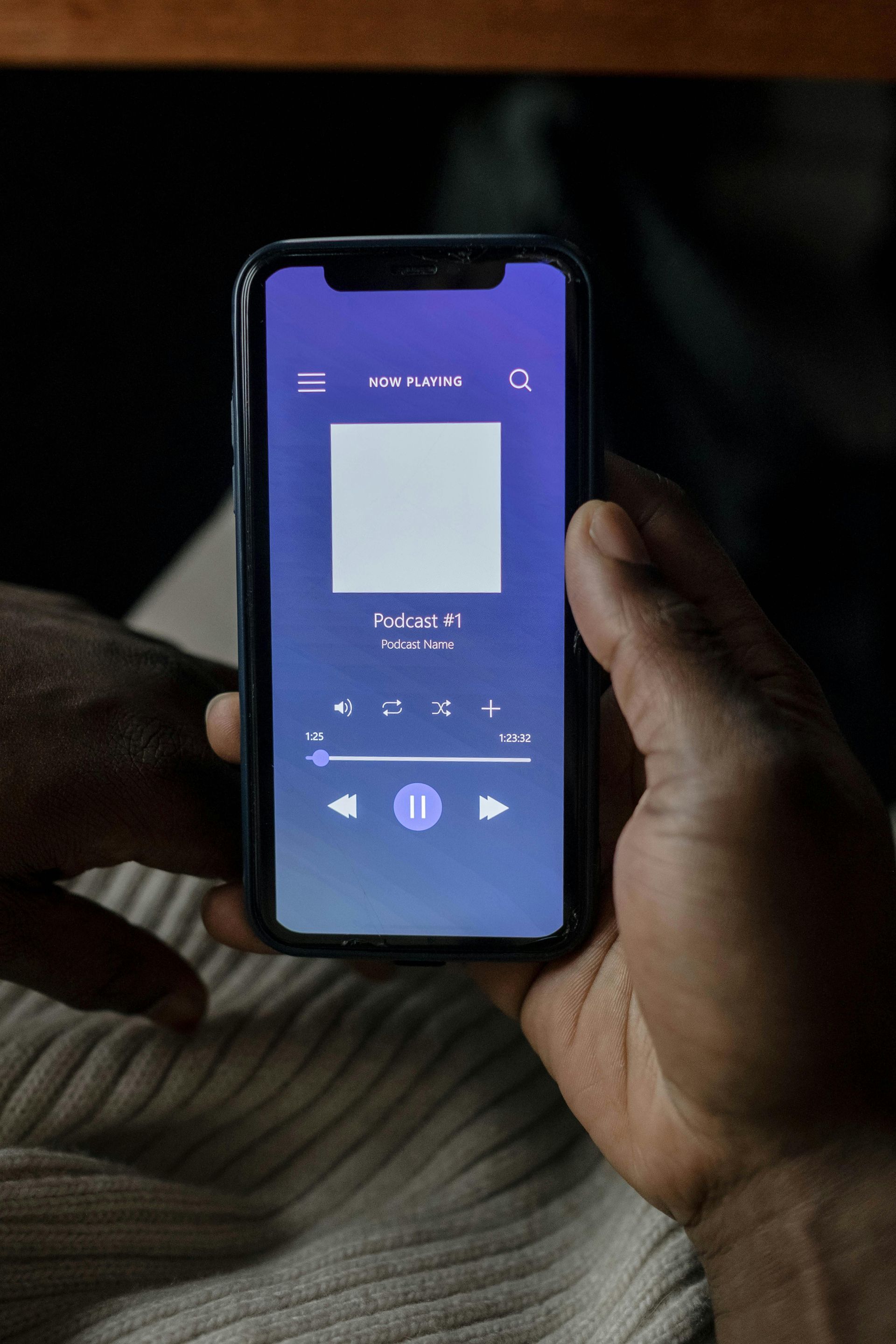 Person holding a smartphone displaying a music player interface. A blue-gradient background.