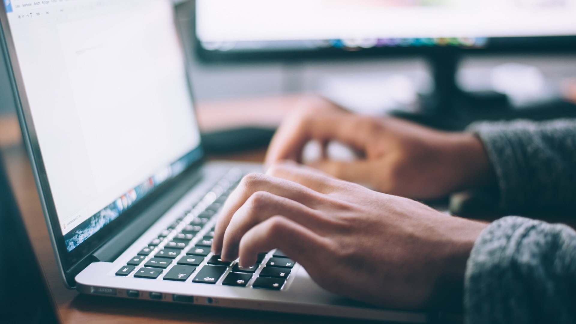 A person is typing on a laptop computer.