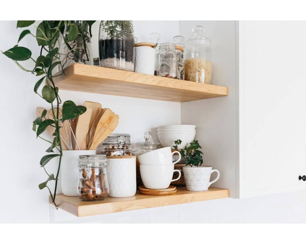Two white shelves with decorative items including plants, books, and a letter Two white shelves with decorative items including plants, books, and a letter