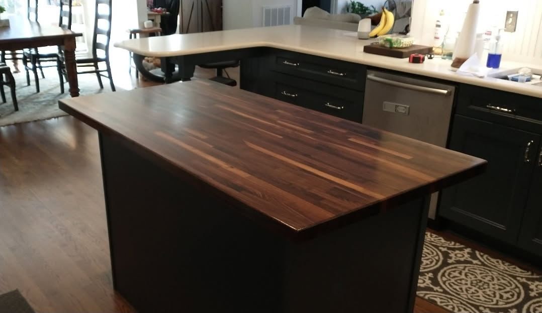 Rustic kitchen with wood cabinets, blue island, stainless steel fridge, and window view. Rustic kitchen with wood cabinets, blue island, stainless steel fridge, and window view.
