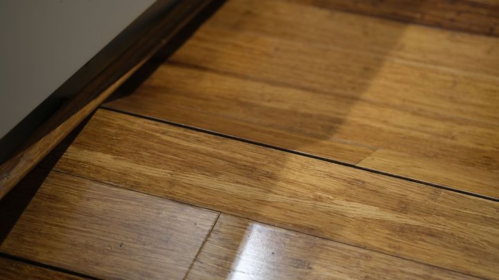 Wooden flooring with a dark seam and a glossy finish.