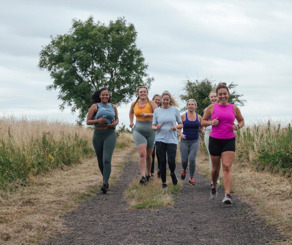 A group of women are running down a dirt path.