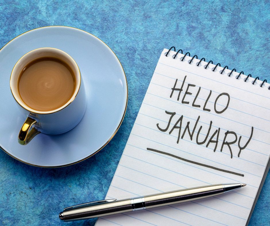 A cup of coffee and a notebook that says hello january