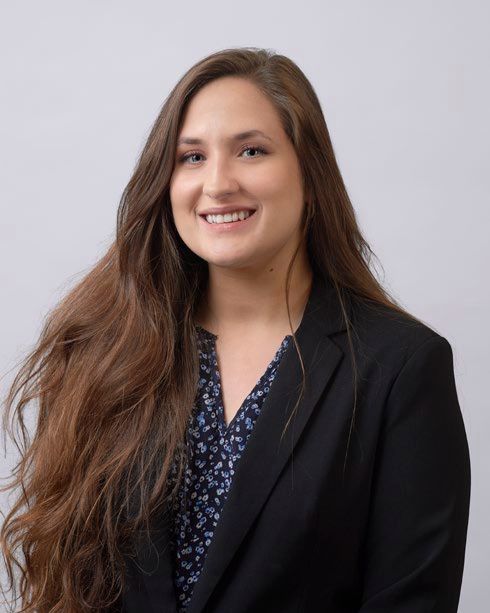 A woman wearing a scarf is smiling for the camera.