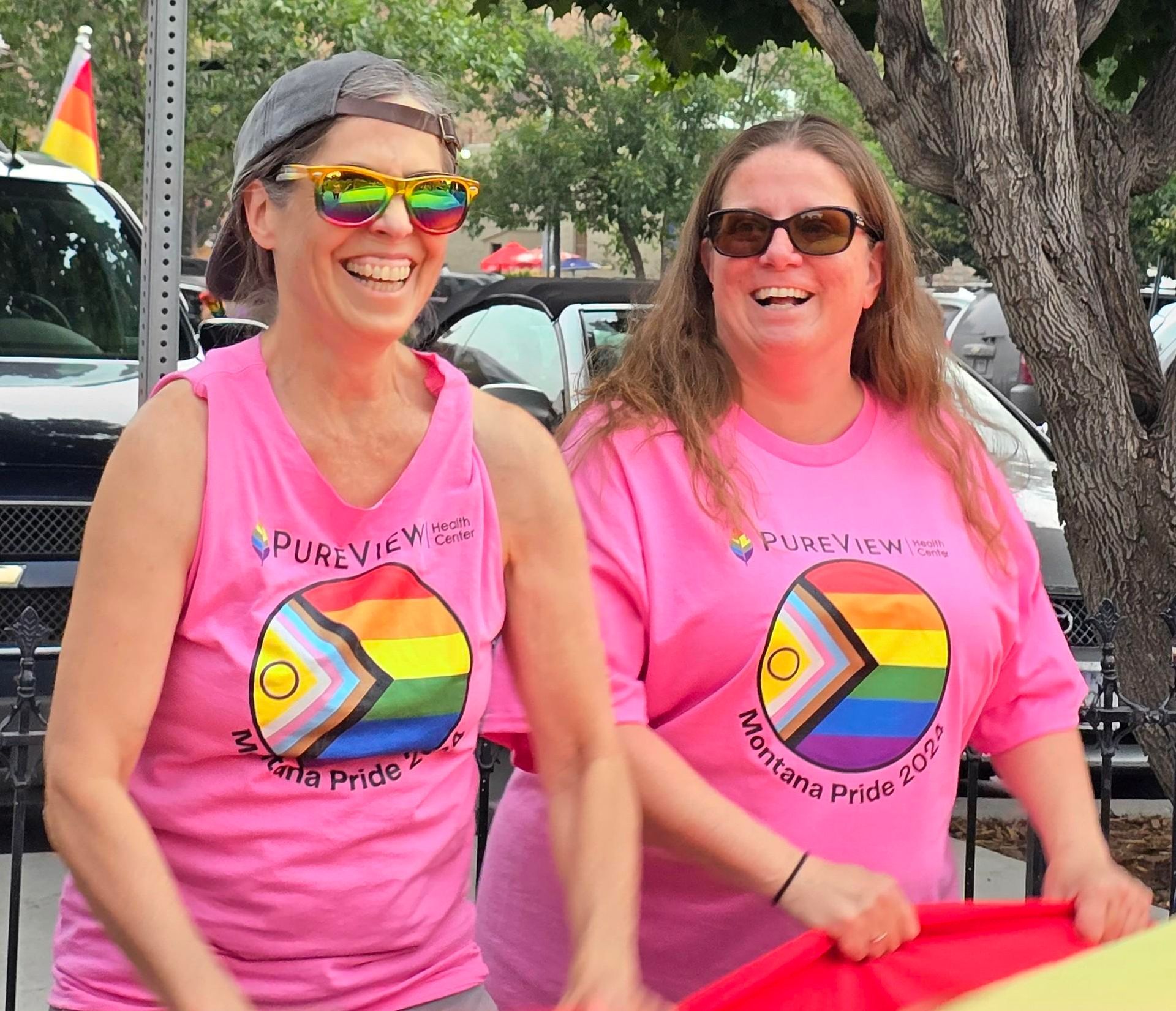 Two women wearing pink shirts with the word pureview on them