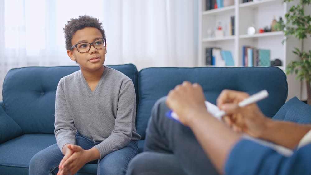 Youth therapy or behavioral health session where a child is speaking to a counselor about emotional 