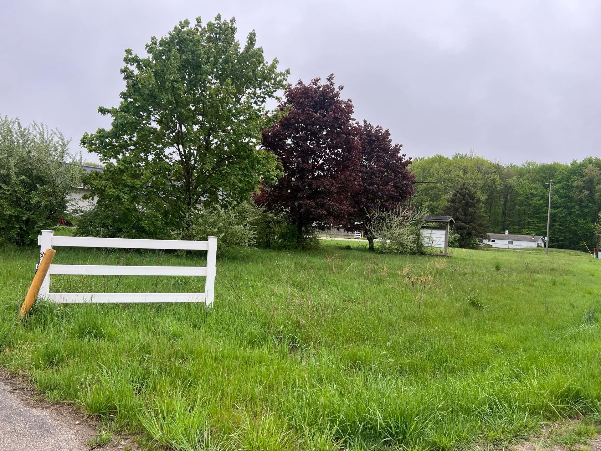 A white fence is sitting in the middle of a grassy field.