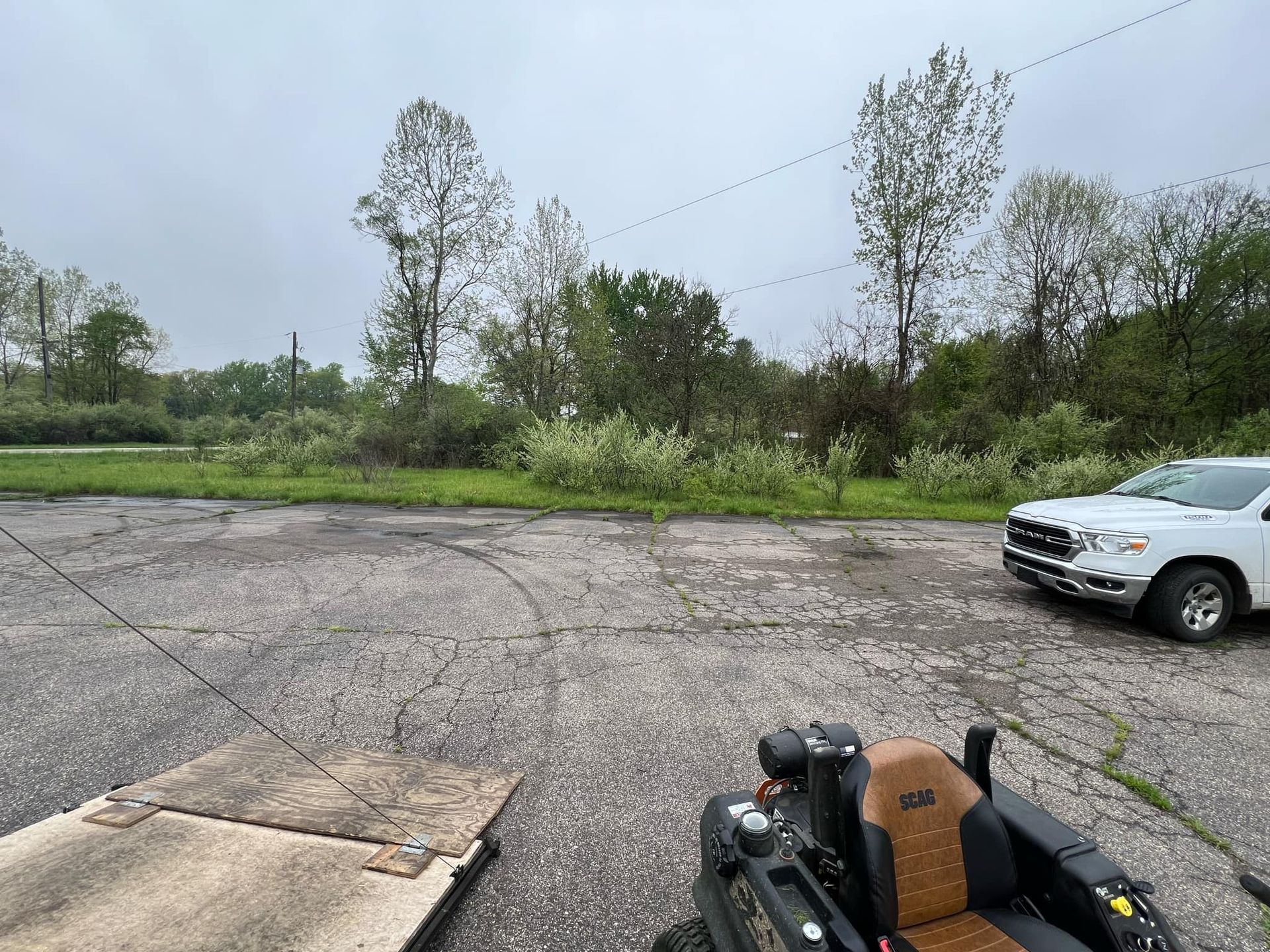 A white truck is parked in a parking lot next to a go kart.