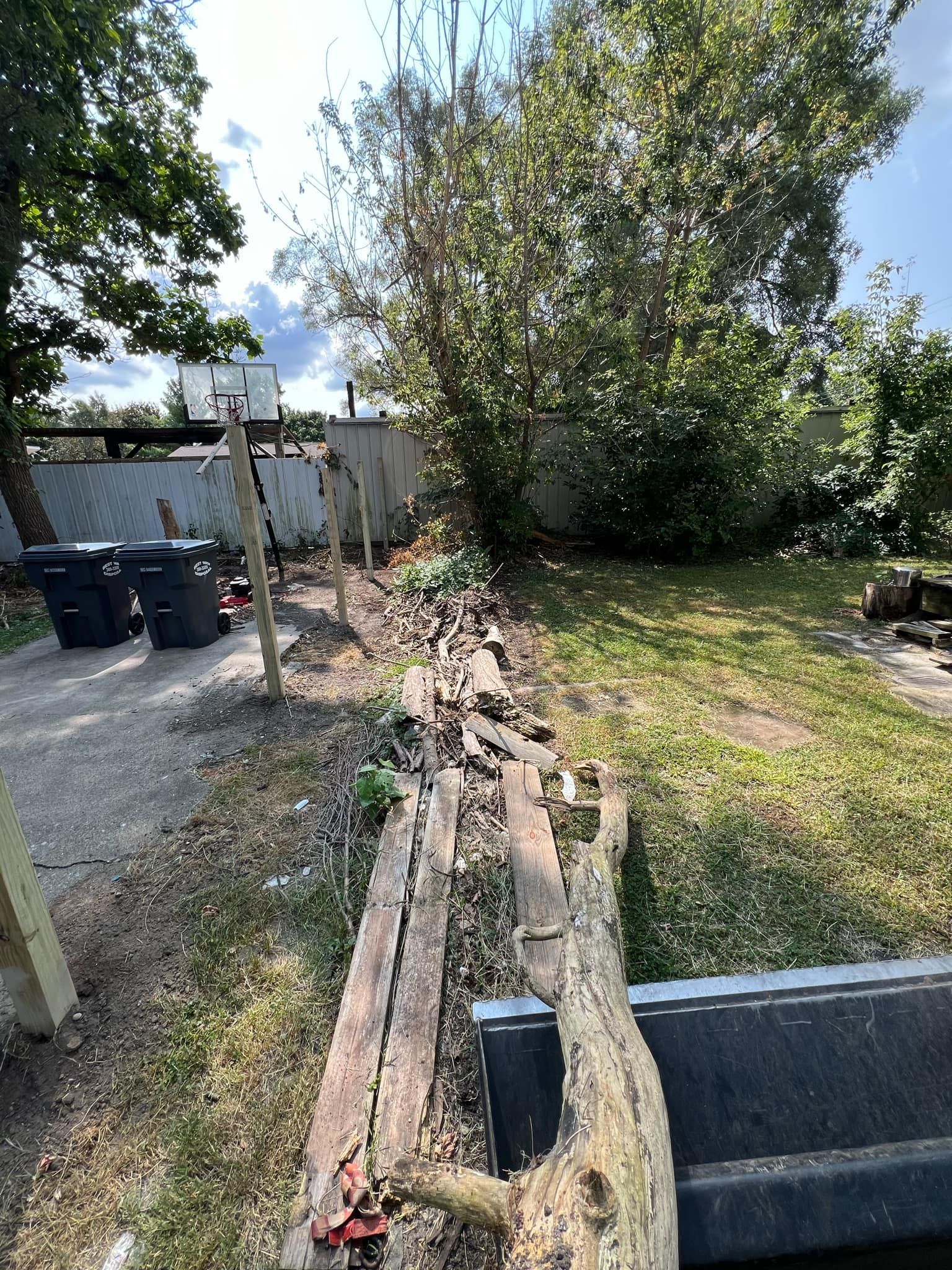 There is a large log in the middle of the yard.