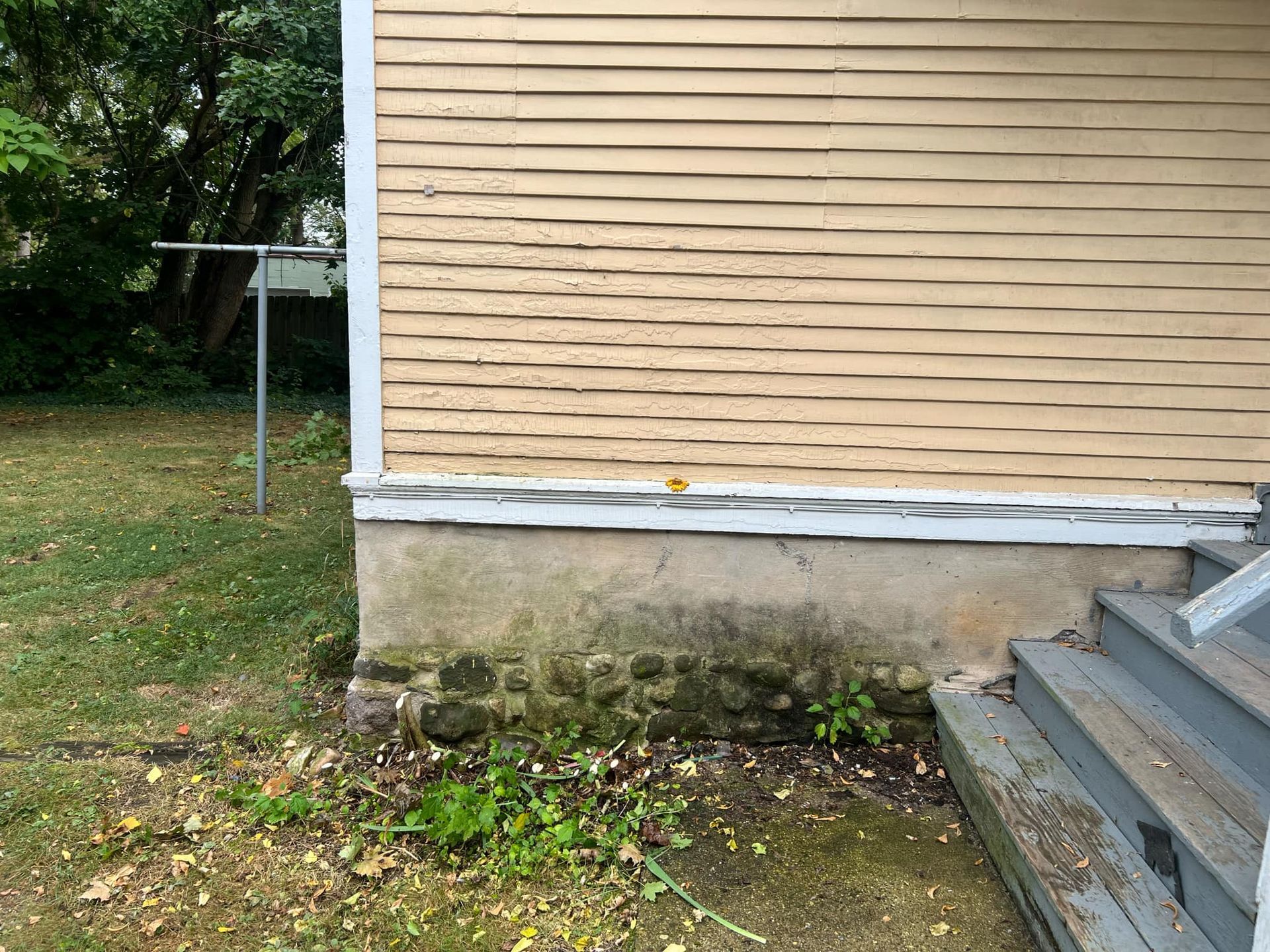 The side of a house with stairs leading up to it.