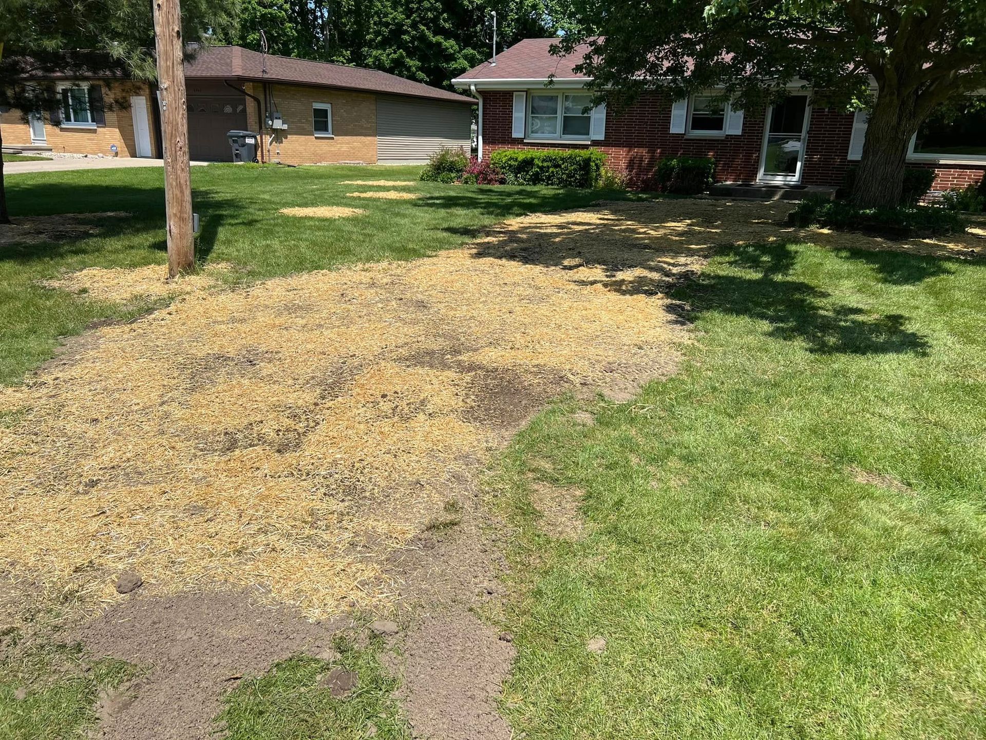 A house with a lot of grass and dirt in front of it.