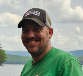 A man wearing a hat that says tractor supply on it