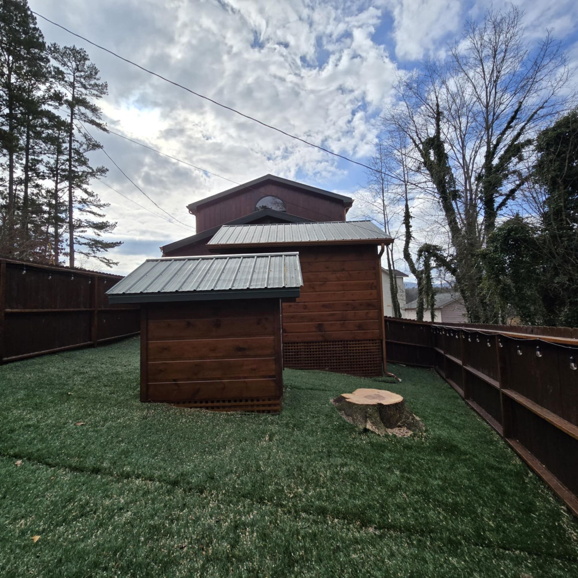 A backyard with a wooden shed and a fence