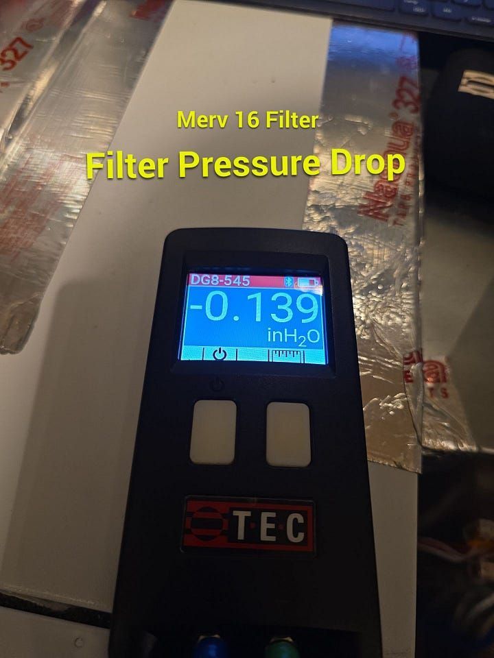 Handheld meter showing Merv 16 filter pressure drop at -0.139 inH2O on ductwork insulation