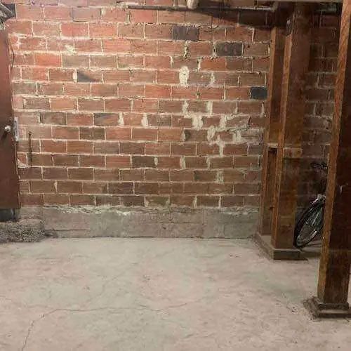 There is a brick wall in the corner of the room.