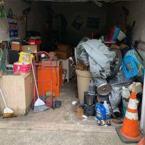A garage filled with lots of junk and cones.