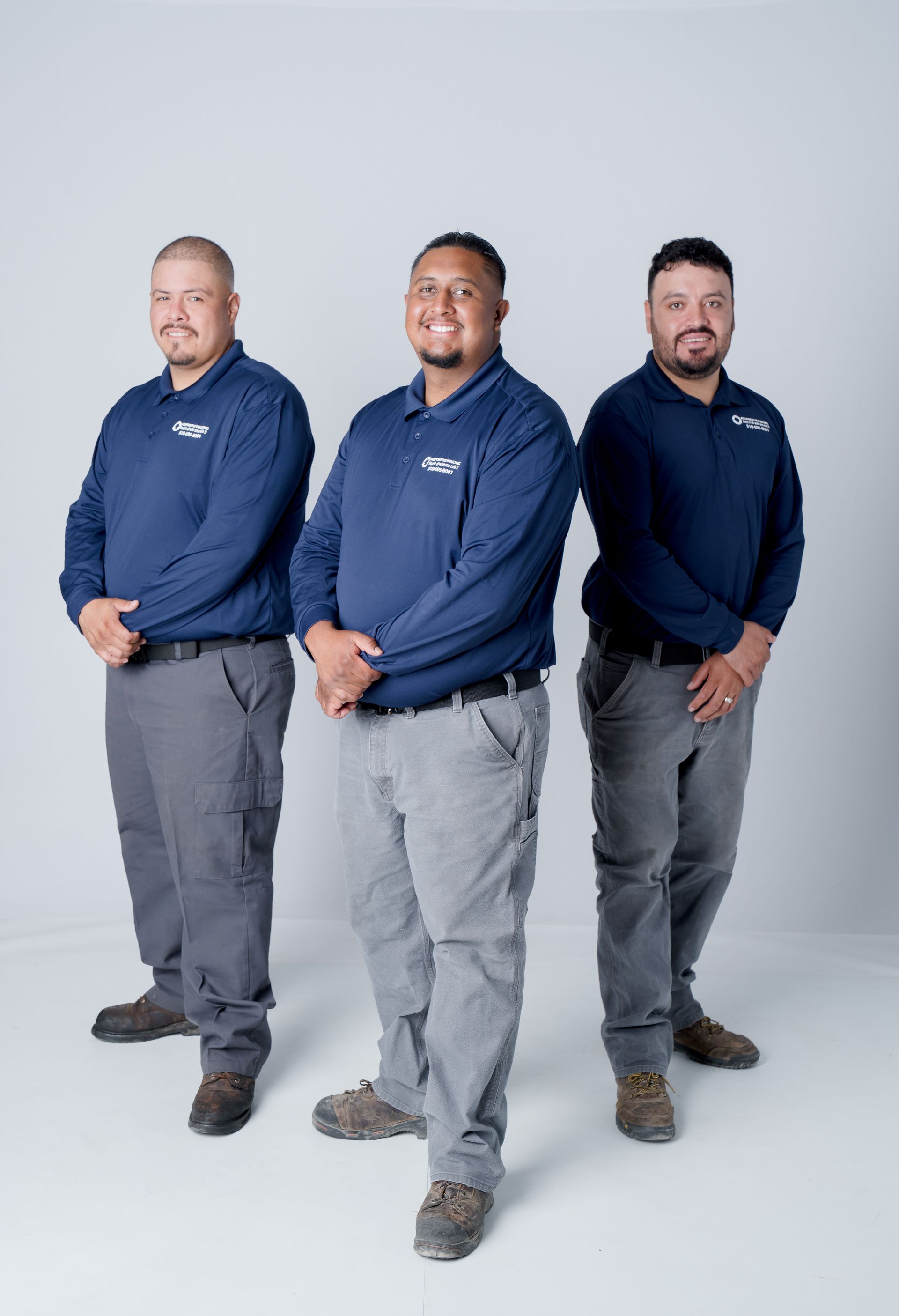 Three men stand confidently side by side.