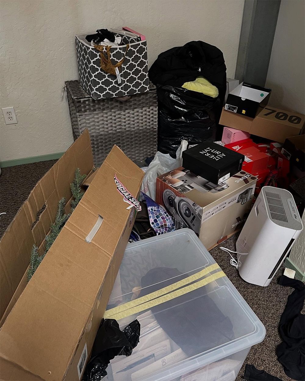 A room filled with boxes and a trash bag that says ' venus ' on it