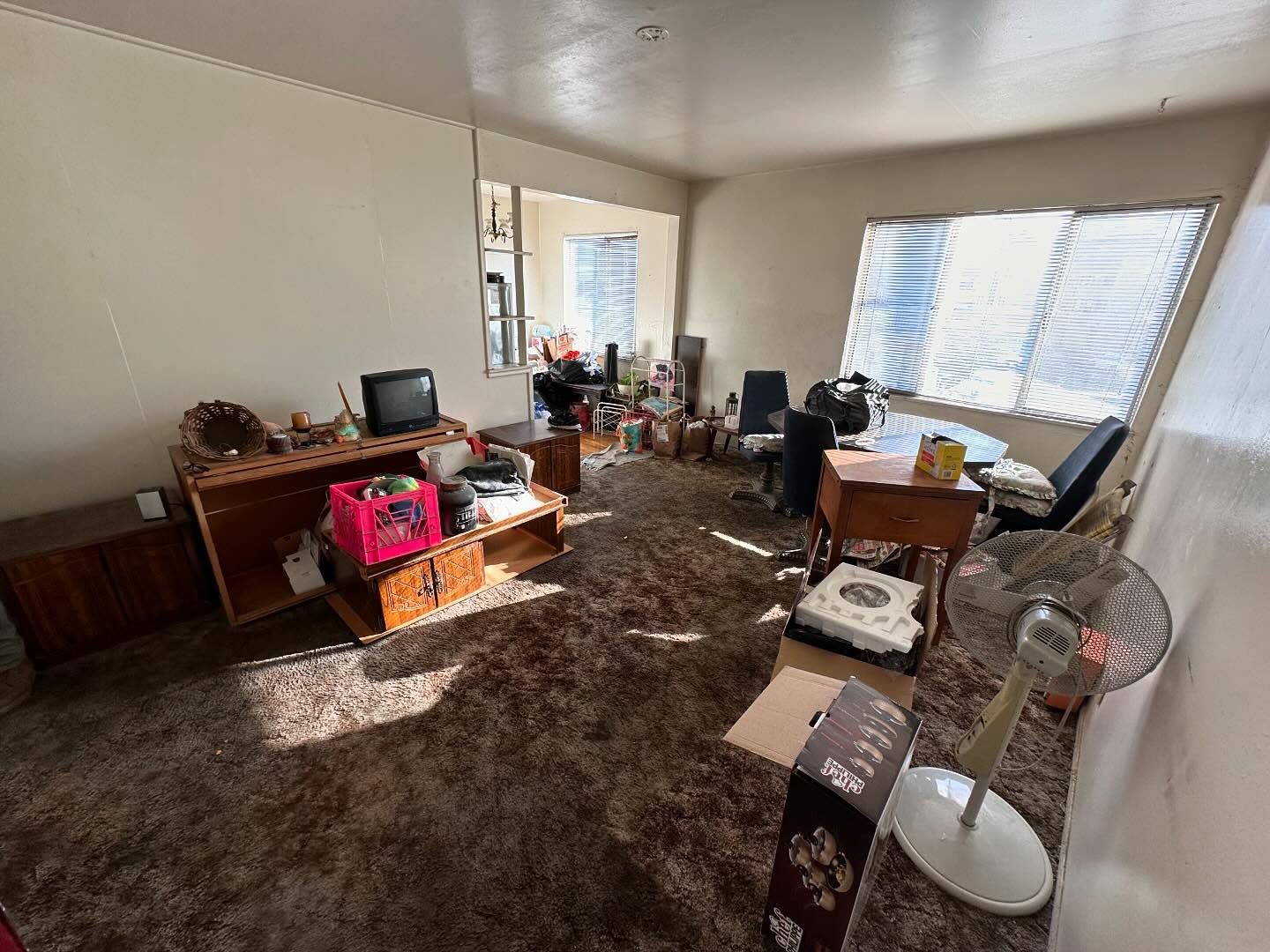 A living room filled with furniture and a fan.