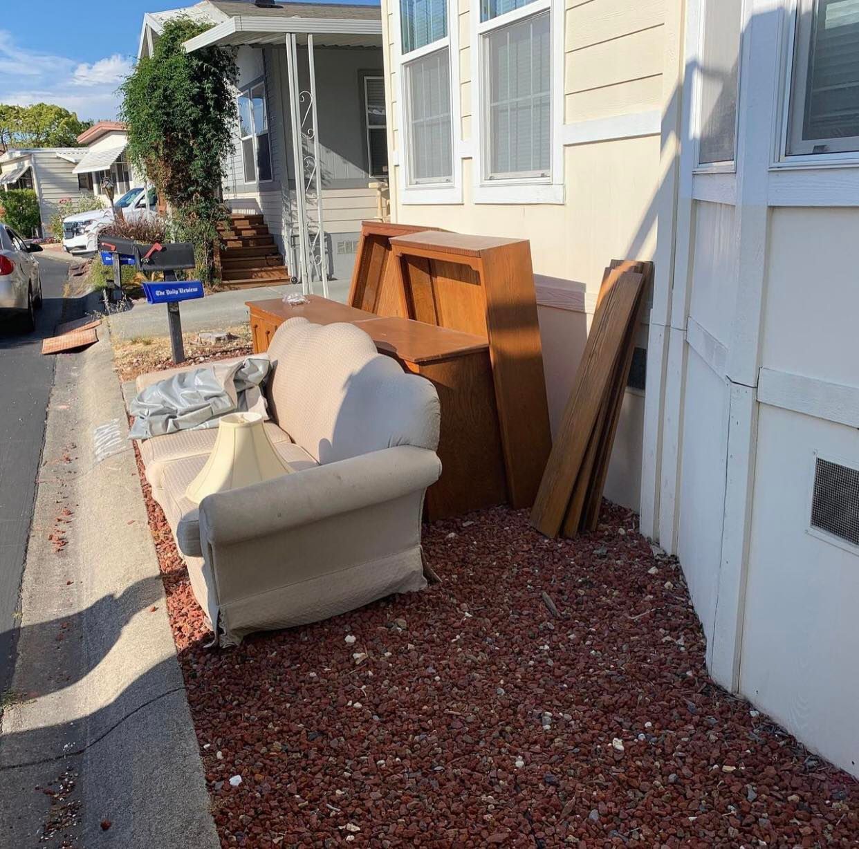 A couch and a piano are sitting outside of a house