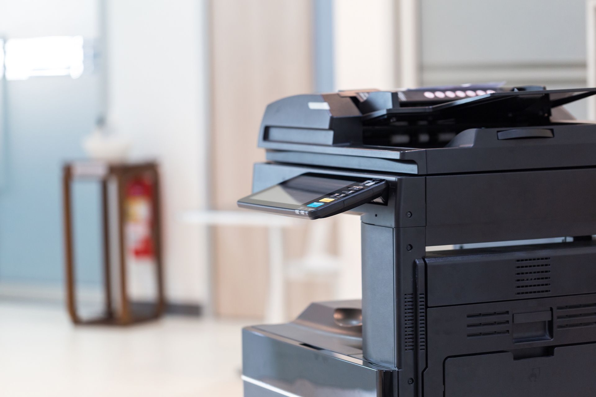 A black printer is sitting on a table in a room.