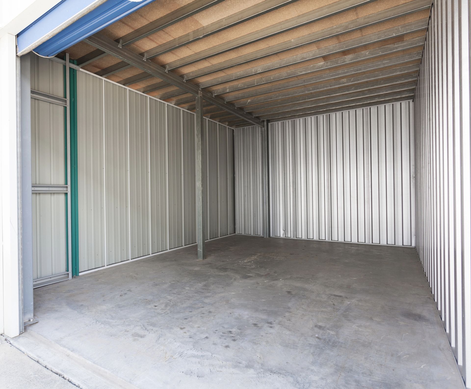 An empty garage with a door open and a window.