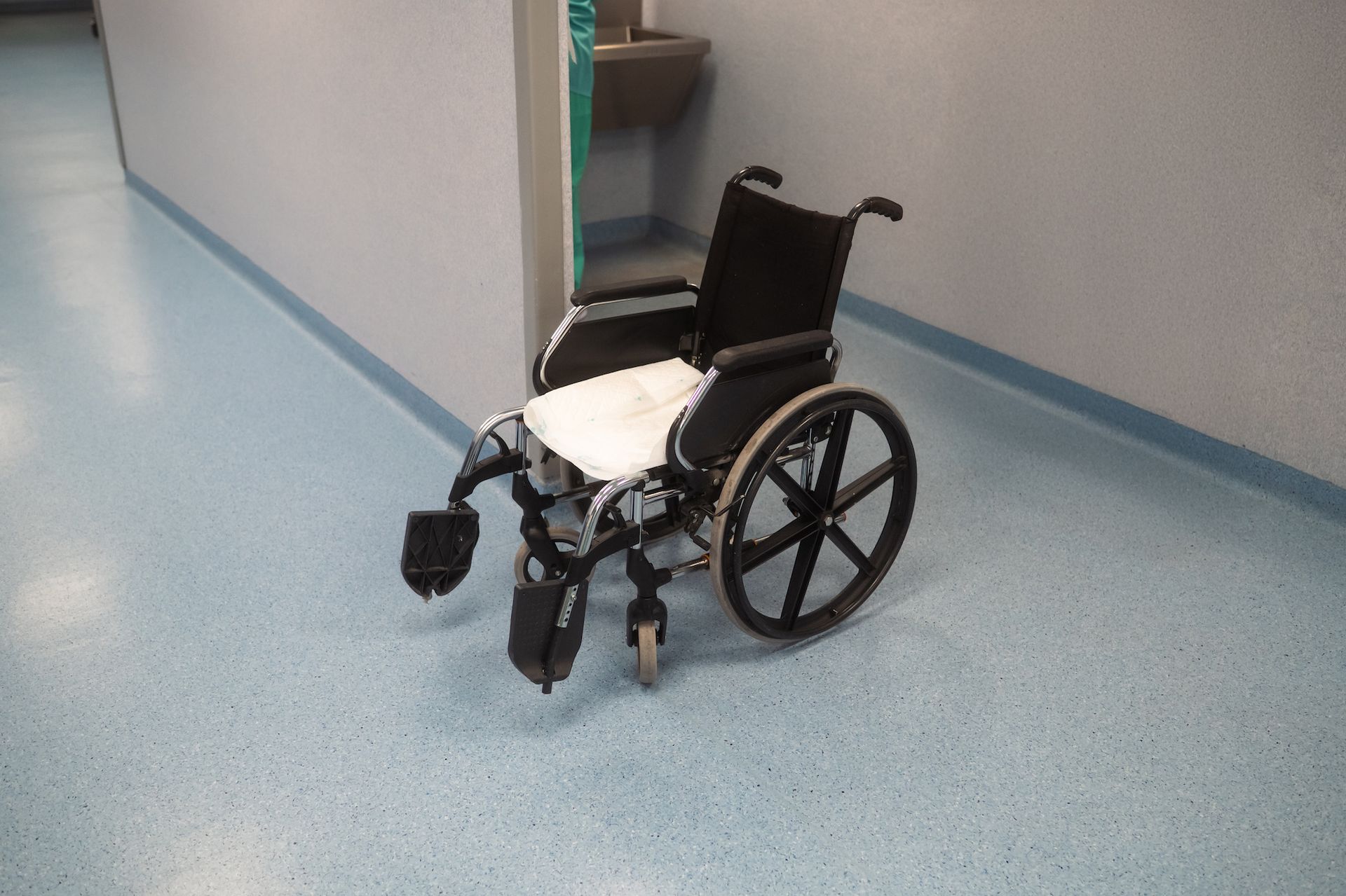 A wheelchair is sitting on the floor in a hallway