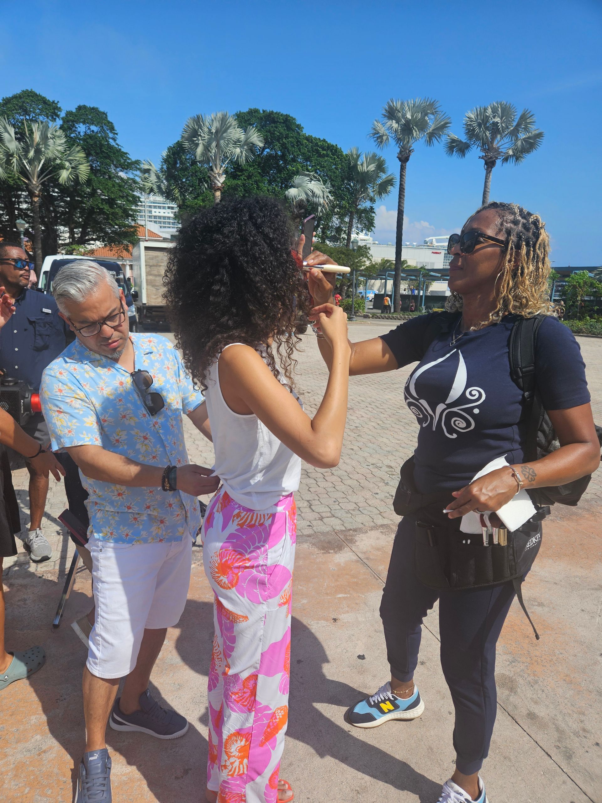 A group of people are standing next to each other on a sidewalk.
