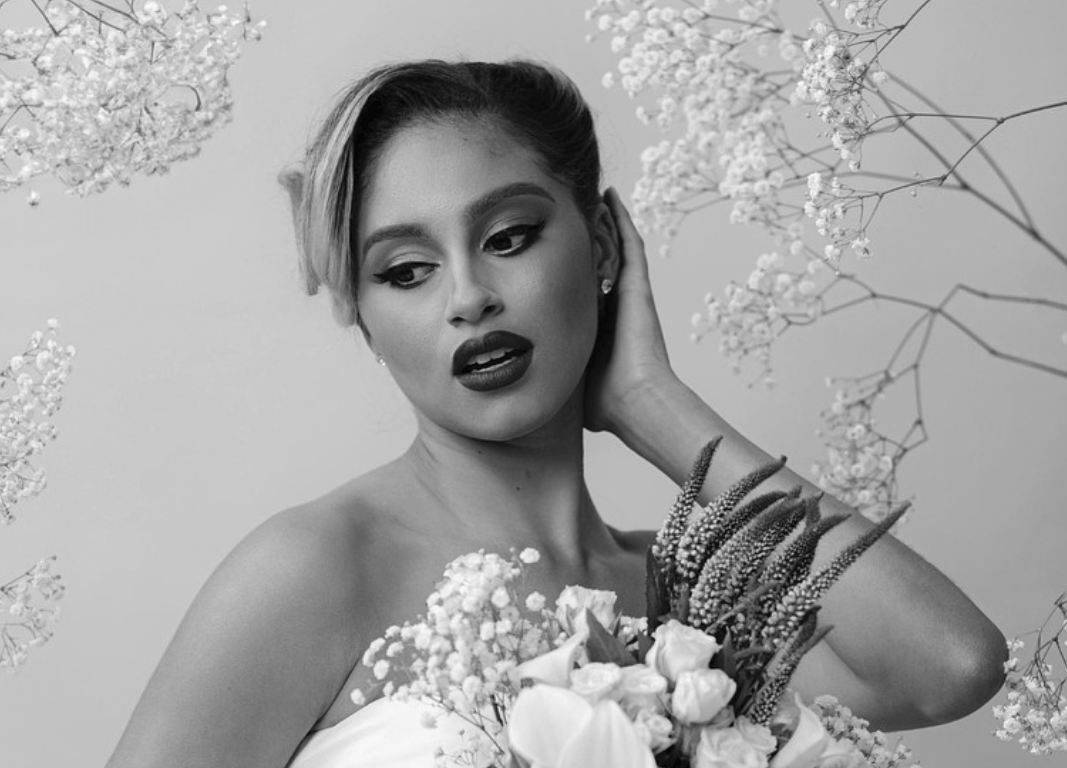A black and white photo of a woman holding a bouquet of flowers.