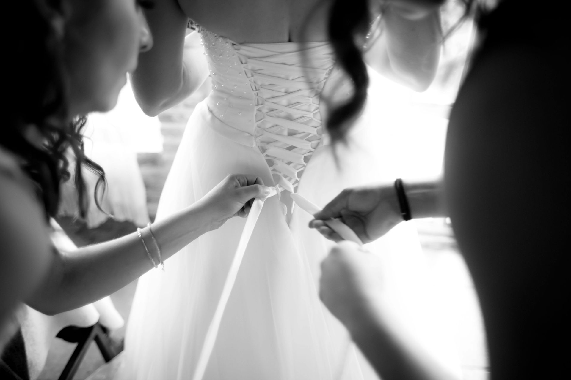 A black and white photo of a bride getting ready for her wedding.