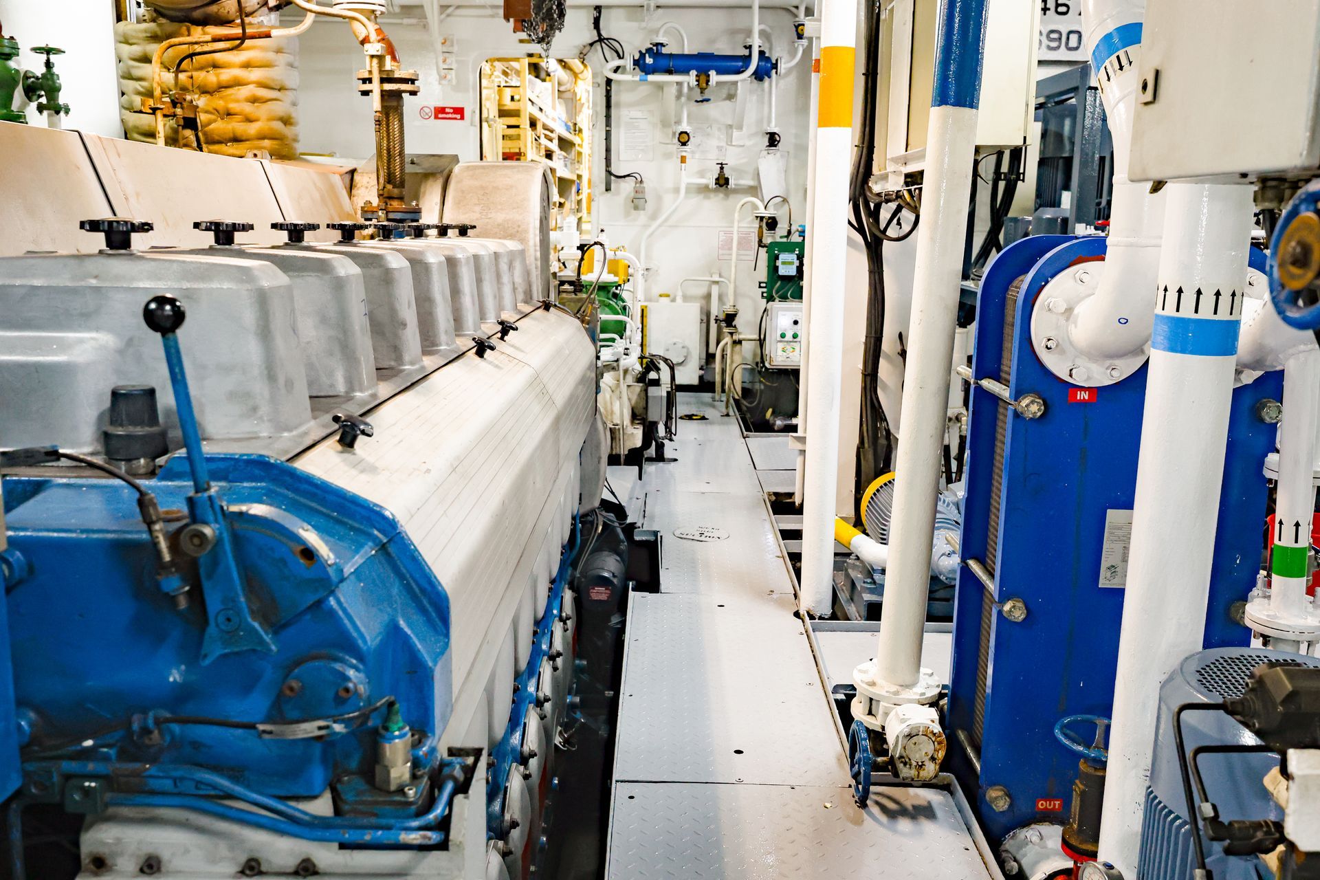 A marine diesel engine with a control panel and an exhaust system inside the ship's engine room.