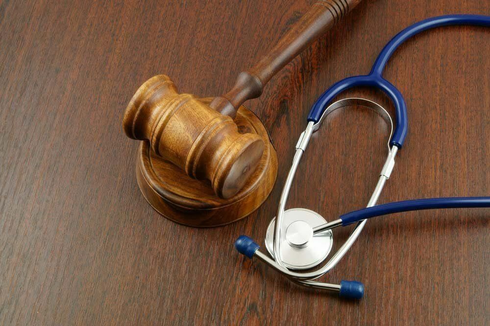 A Wooden Gavel and a Stethoscope Are on a Wooden Table — Tony Love Lawyers in Lismore, NSW