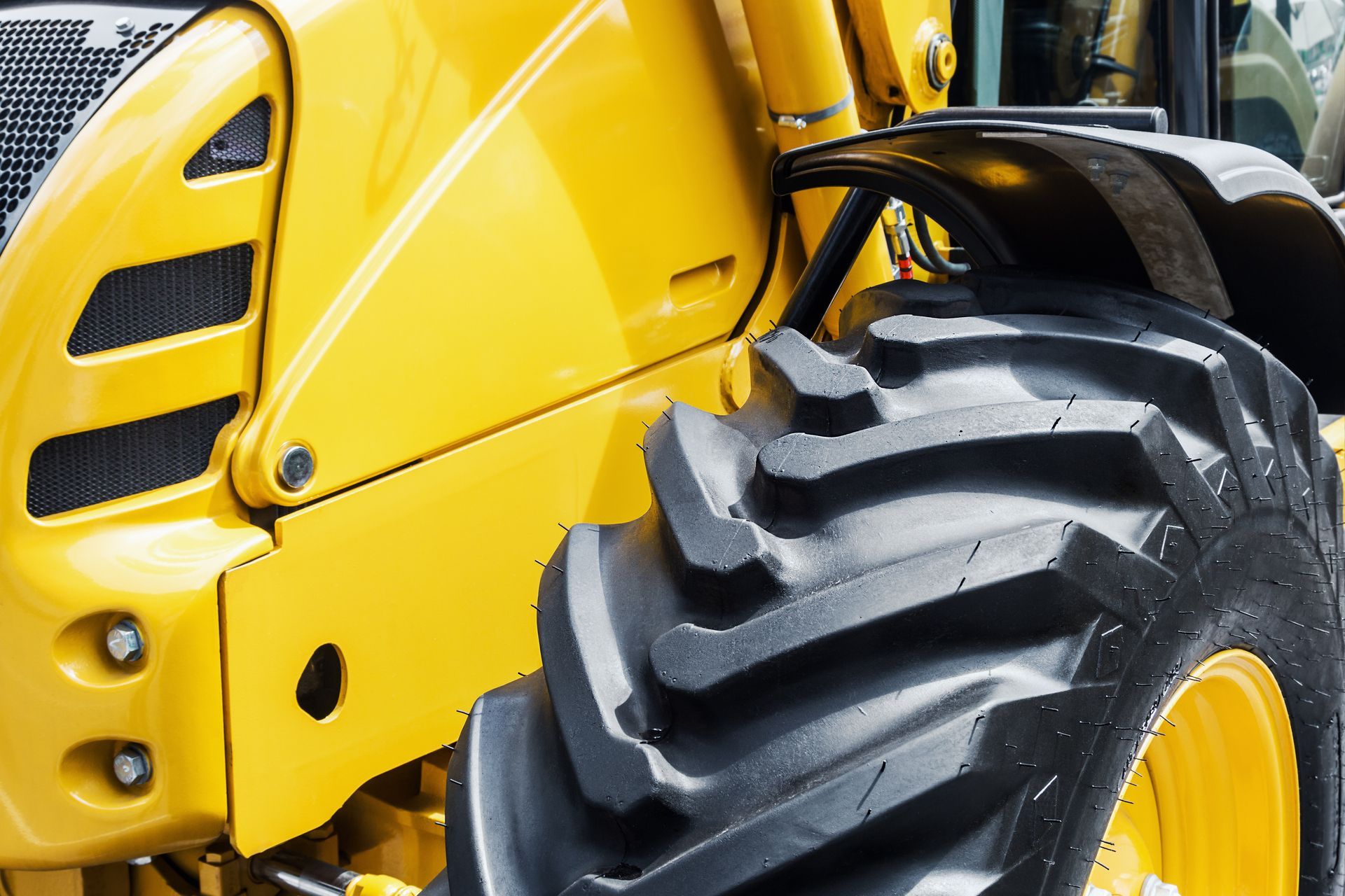 Yellow construction vehicle with a large black tire.