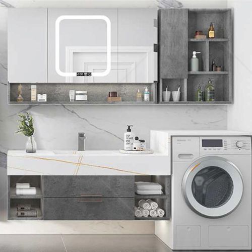 A bathroom with a sink , washer and dryer.