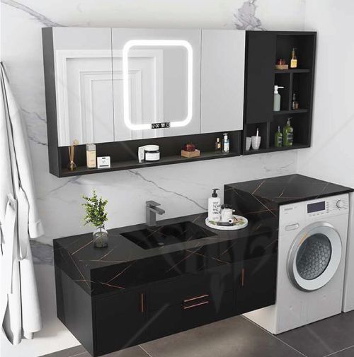 A bathroom with a sink , washer and dryer.