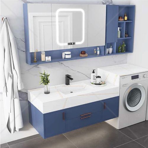 A bathroom with a sink , washer and dryer.