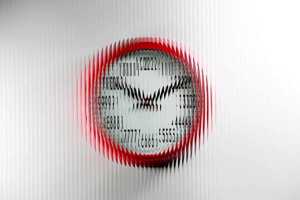 red wall clock with a Reeded design