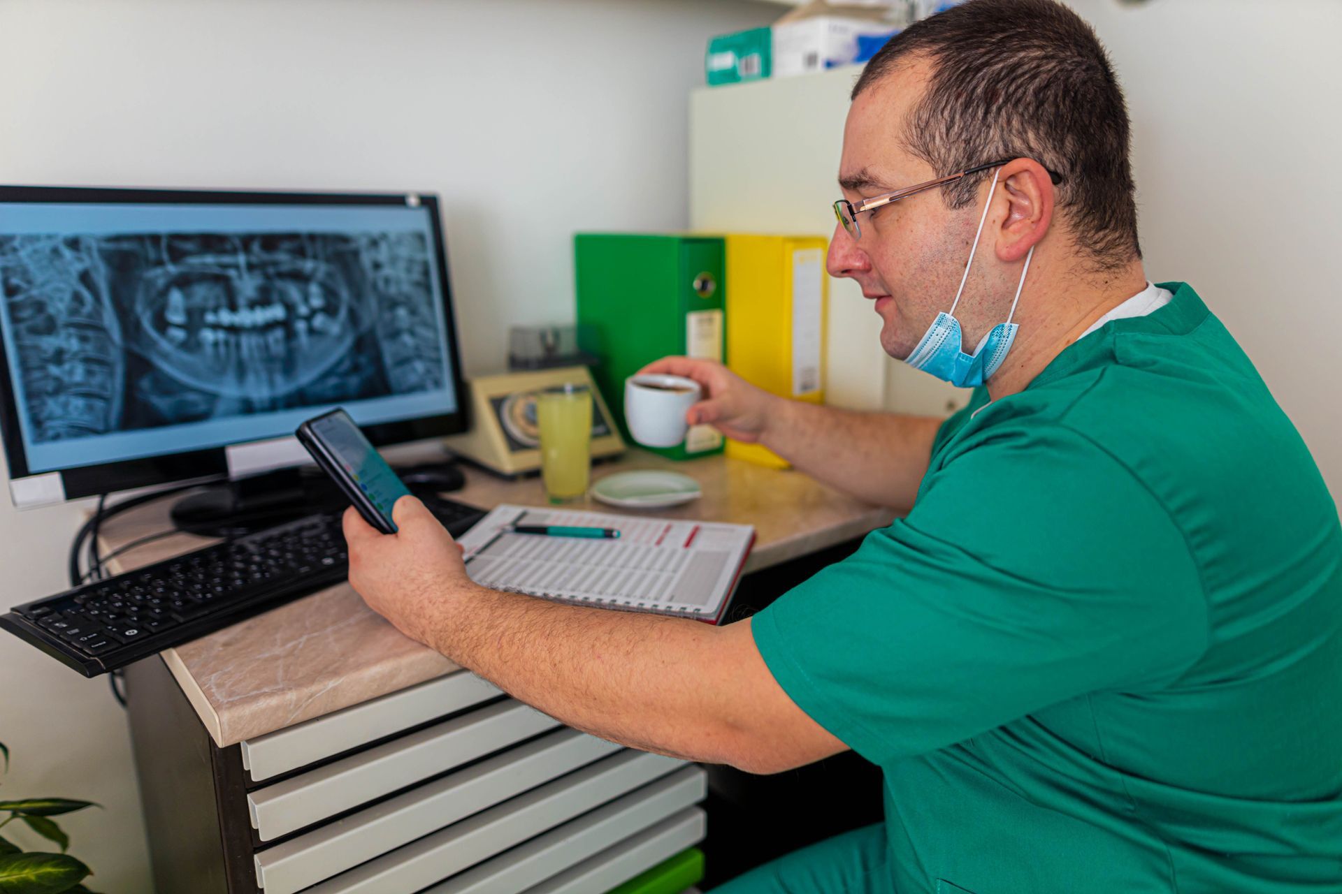 Dentist Using Cellphone While Holding Cup Of Tea — QLD, AUS — Dental IT 365
