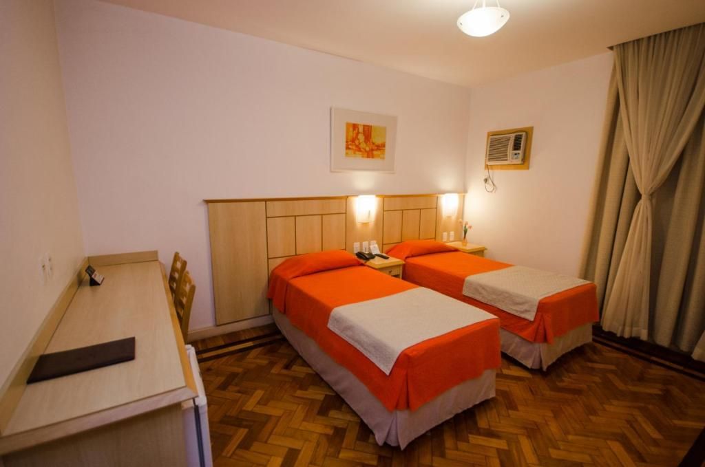 Um quarto de hotel com duas camas e uma cômoda