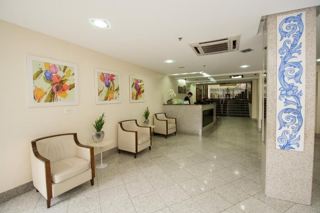 Um lobby com cadeiras e pinturas na parede