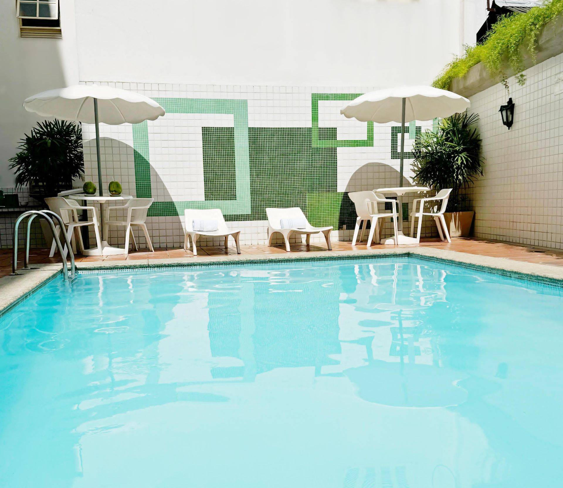 Uma piscina com mesas, cadeiras e guarda-sóis ao redor