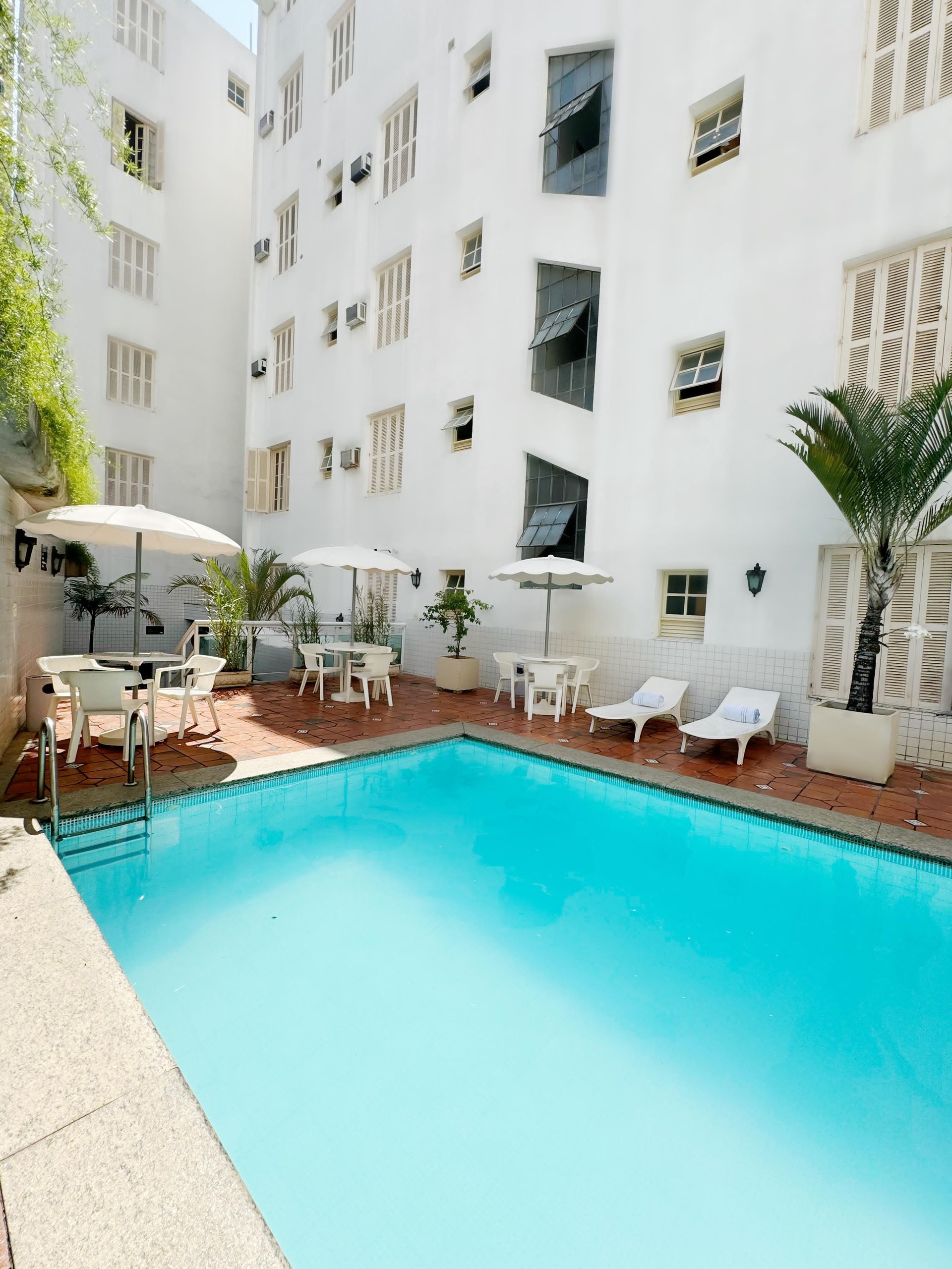 Uma grande piscina em frente a um prédio branco