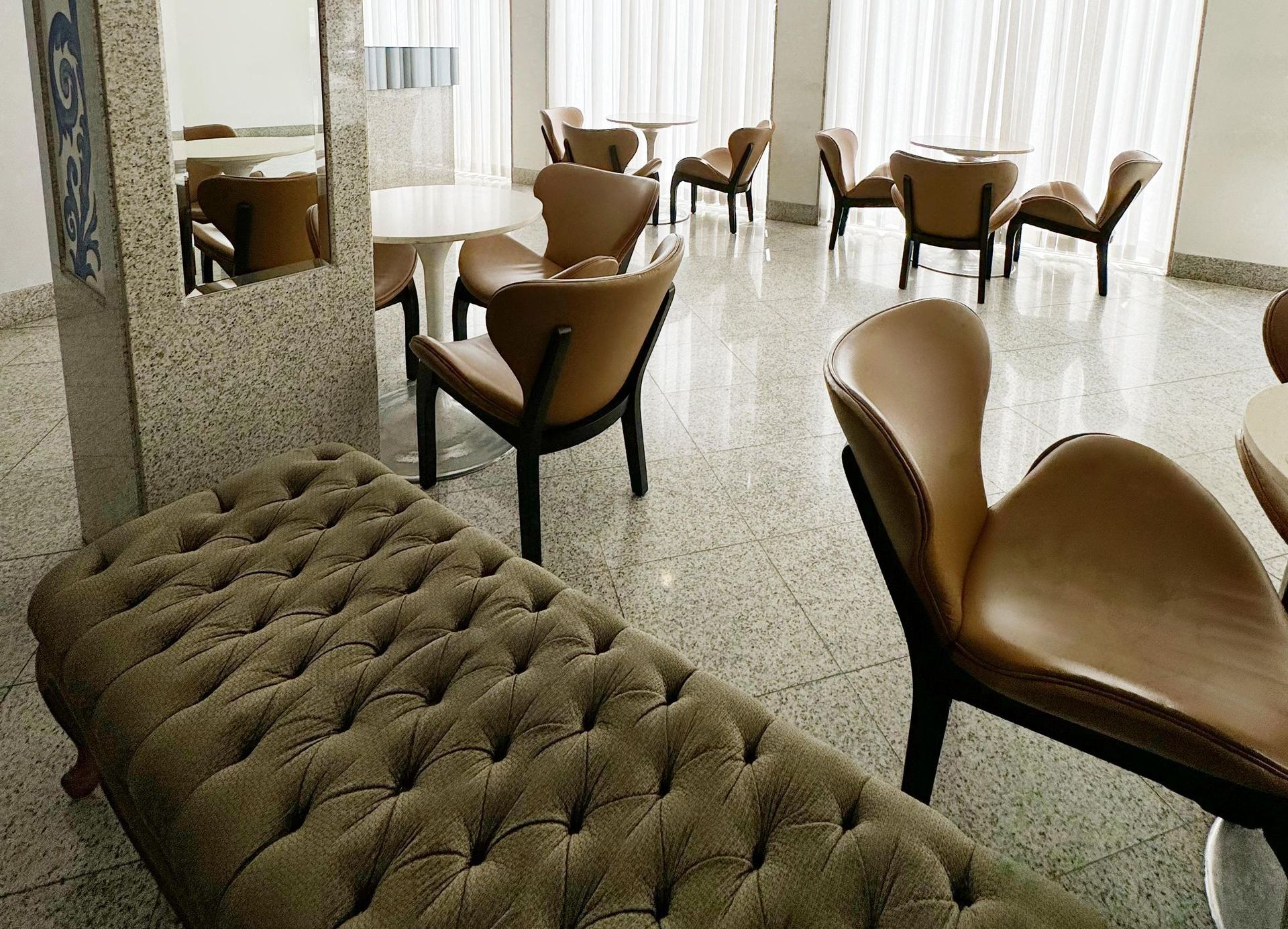 Uma sala com mesas e cadeiras e um banco no meio