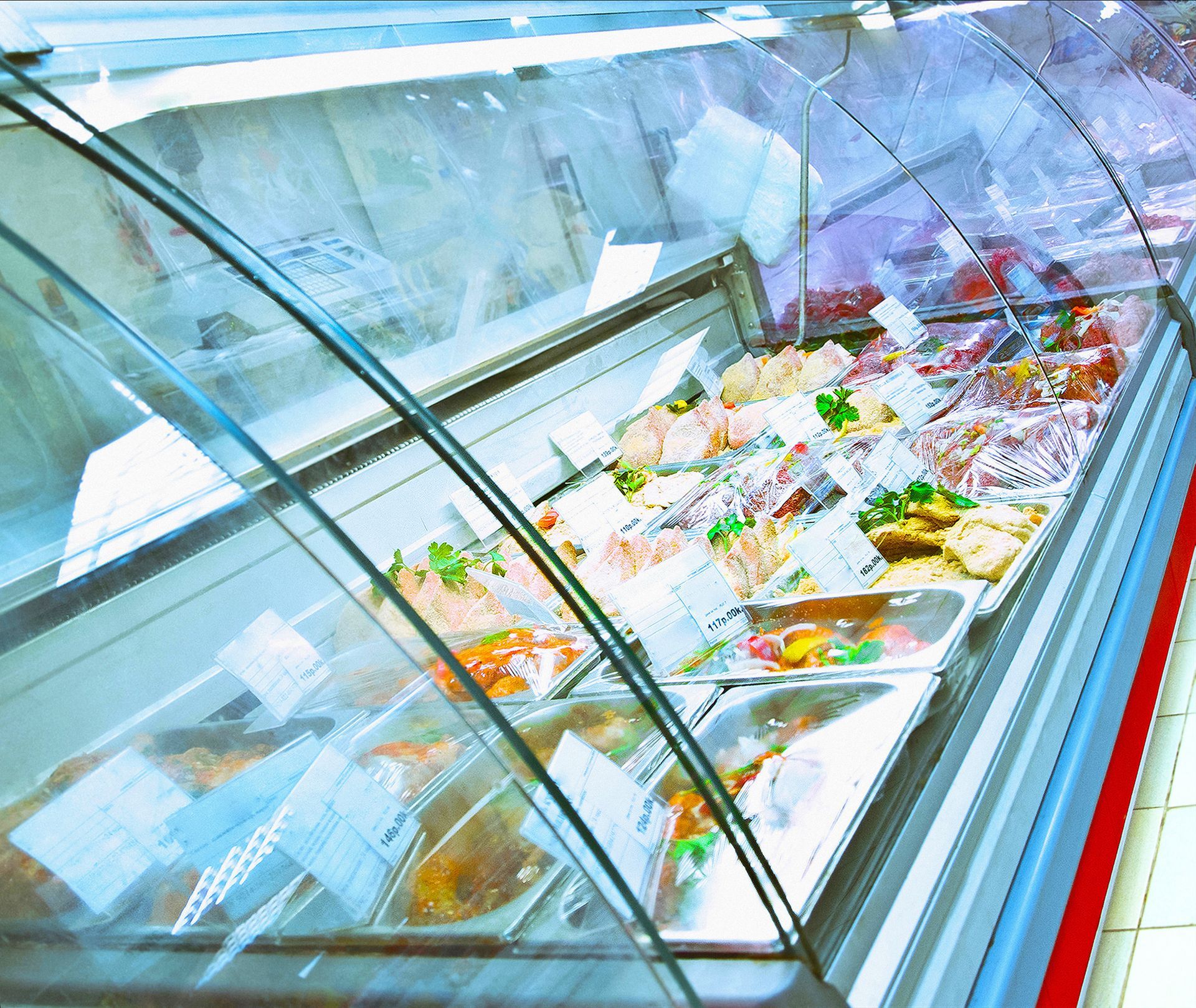 Glass display case filled with assorted colorful packaged foods in a bright store aisle Glass display case filled with assorted colorful packaged foods in a bright store aisle
