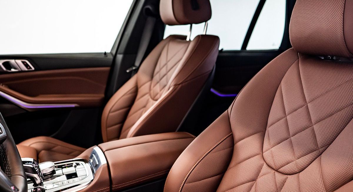 The interior of a bmw x5 with brown leather seats