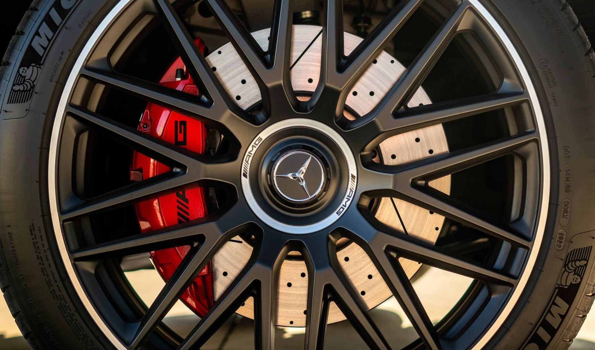 A close up of a car wheel with red brake calipers